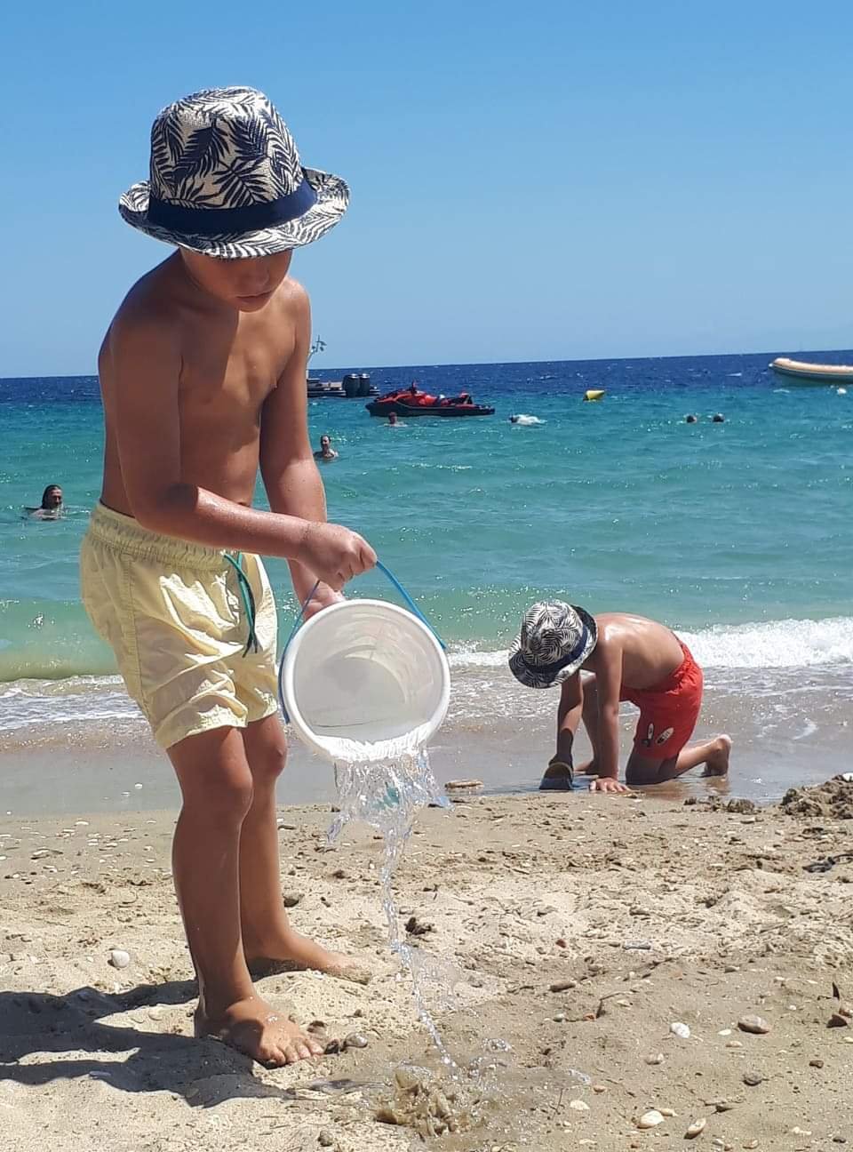 Young children playing with the sand on the beach of Kastri in Southern Pelion Central Greece